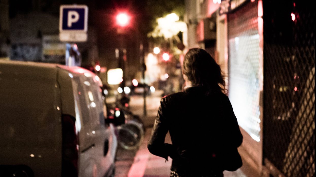 A prostitute walks through the streets at night