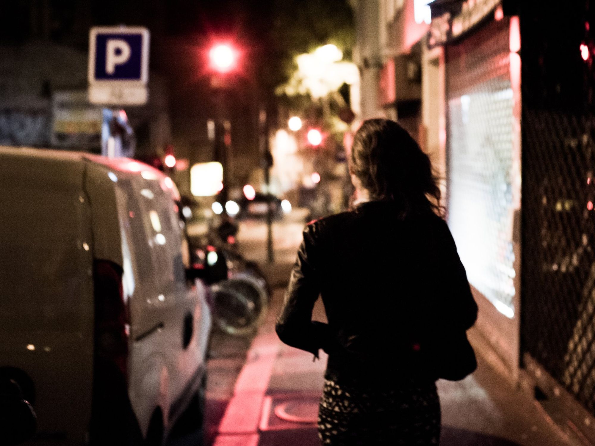 A prostitute walks through the streets at night