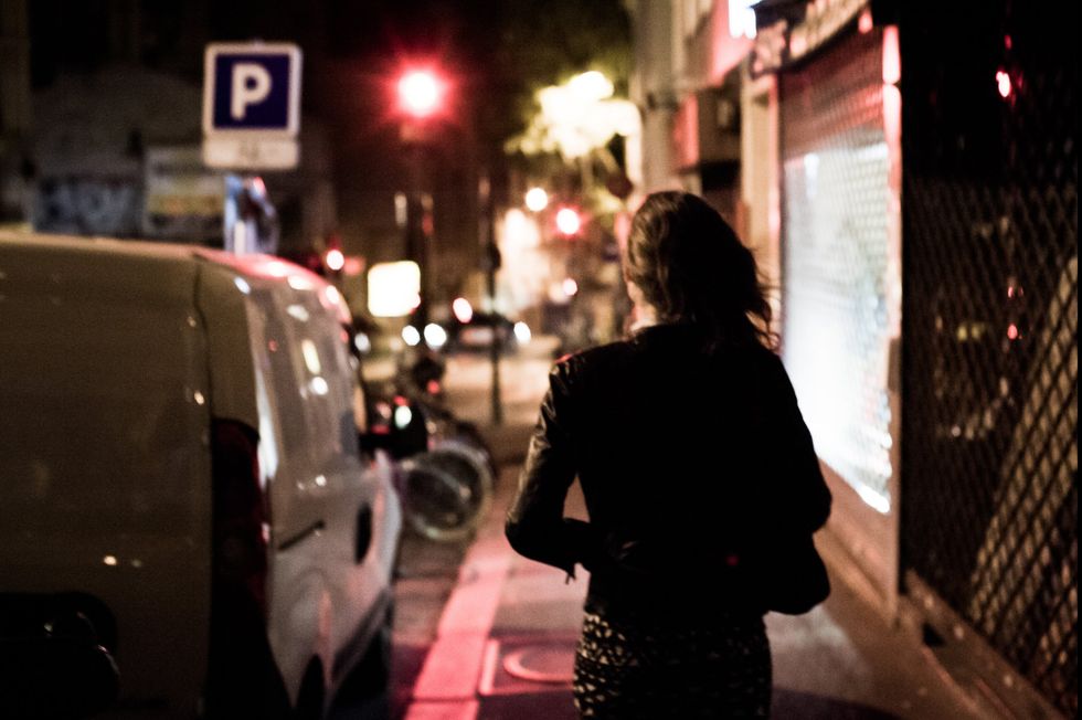 A prostitute walks through the streets at night