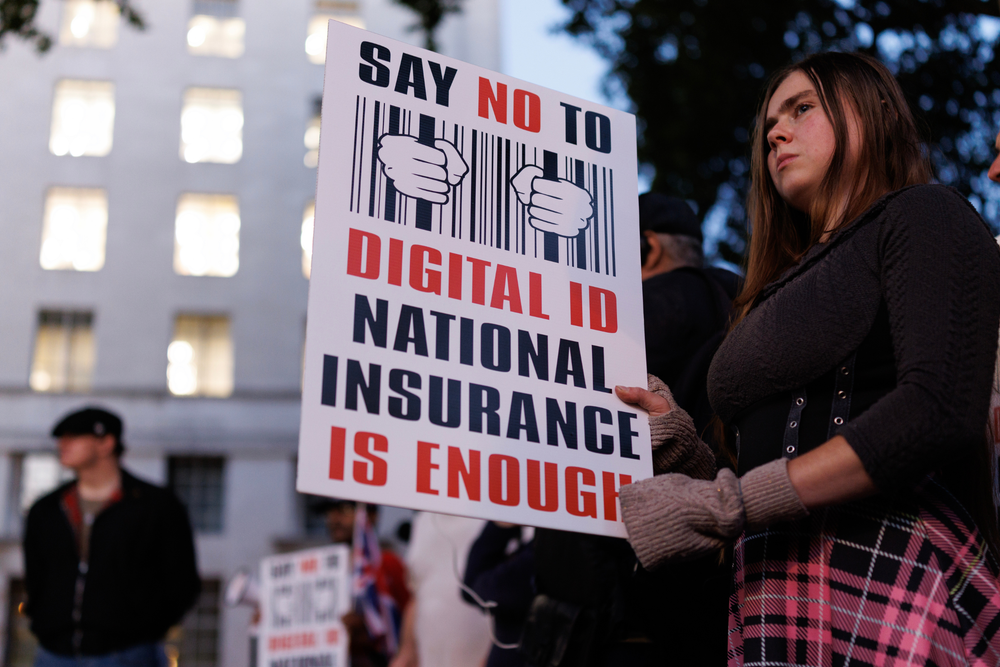 A protester holds a placard decrying digital ID