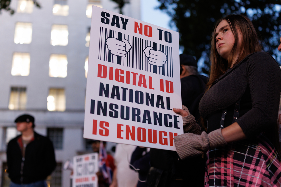 A protester holds a placard decrying digital ID