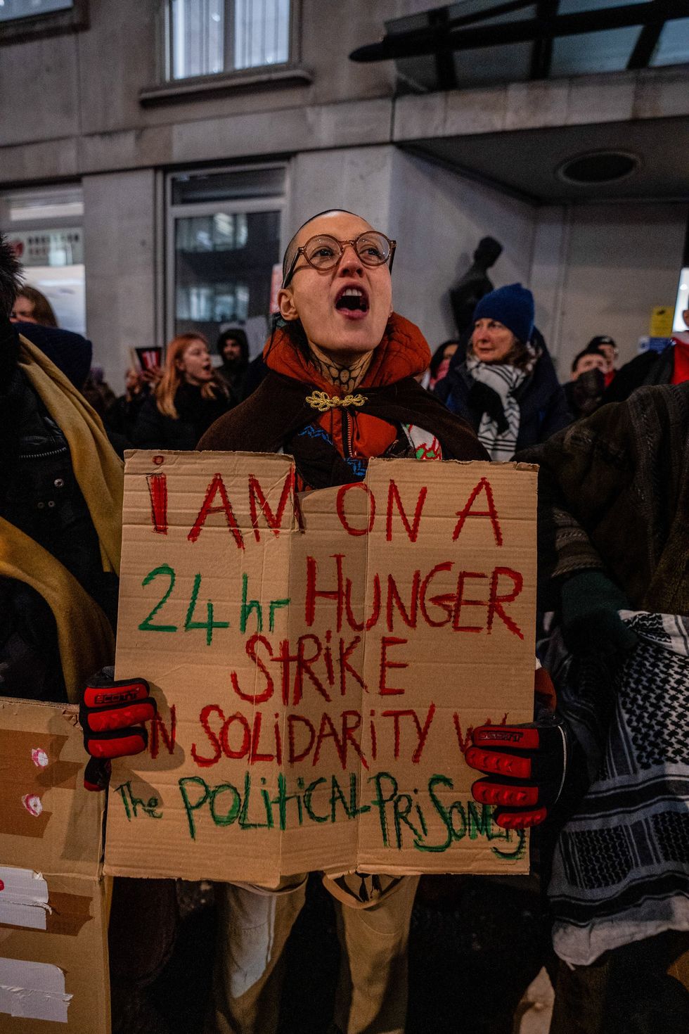 A protester holds a sign saying: 'I am on a 24-hour hunger strike in solidarity with the political prisoners'