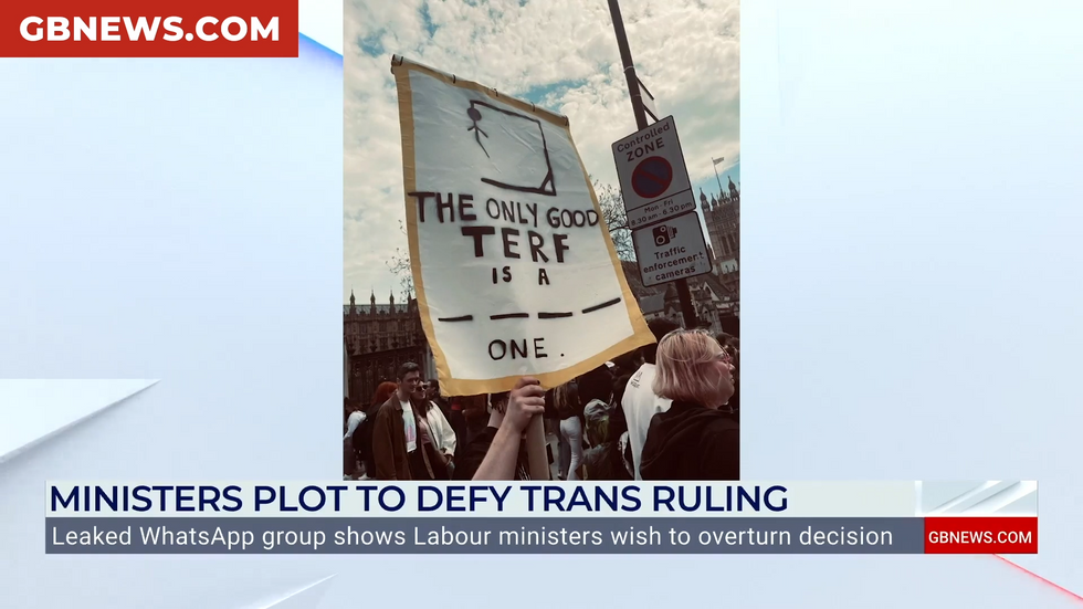 A protester holds aloft a 'the only good terf is a ____ one' sign