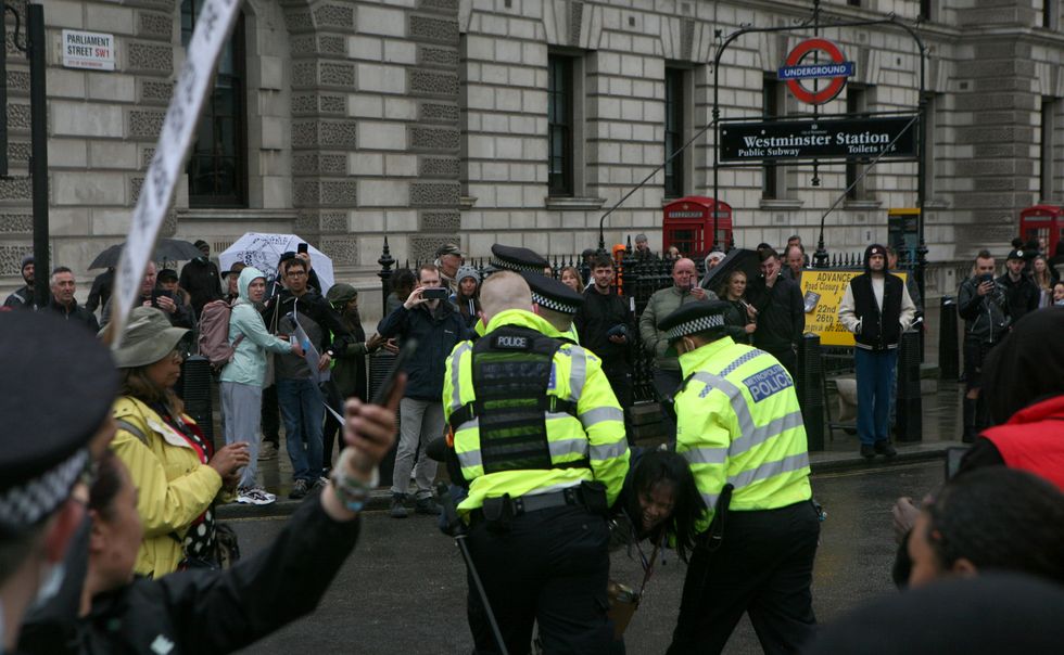 A protester is led away by police officers at an anti-lockdown protest in Parliament Square, London. Picture date: Monday June 21, 2021.