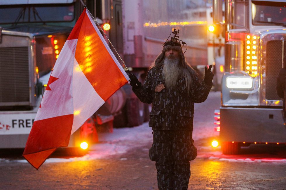 A protester stands next to trucks across from Parliament Hill as truckers and supporters continue to protest coronavirus disease (COVID-19) vaccine mandates, in Ottawa, Ontario, Canada, February 4, 2022. REUTERS/Lars Hagberg
