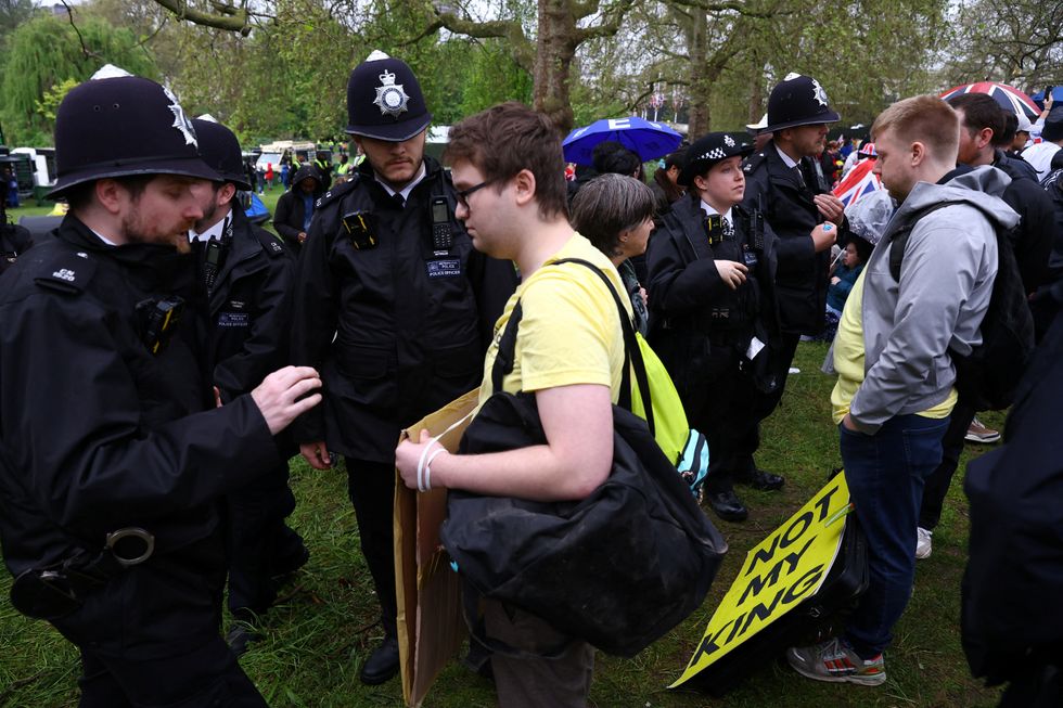 A protester stands with police officers as people gather on The Mall in London