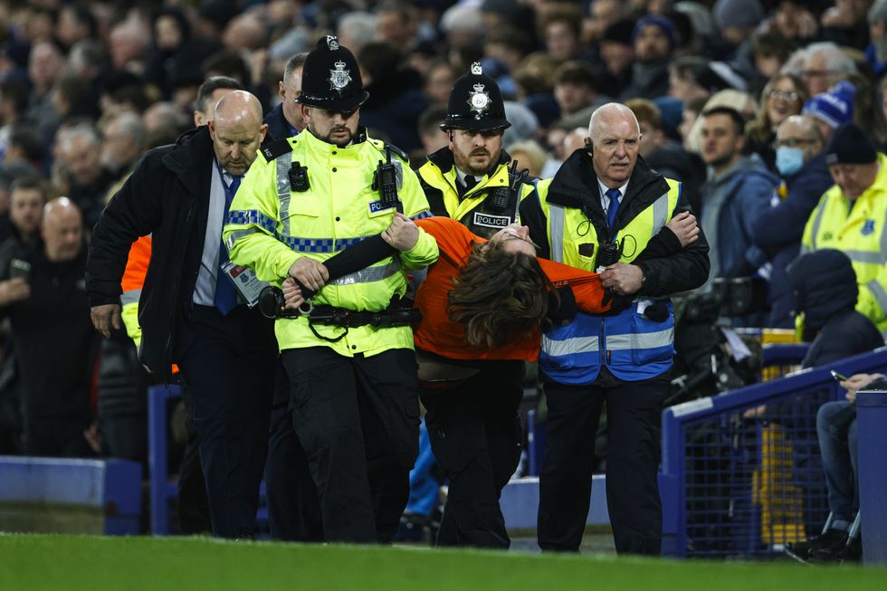A protester that tied himself to the goal frame is ejected from the stadium by police during the Premier League match at Goodison Park, Liverpool. Picture date: Thursday March 17, 2022.