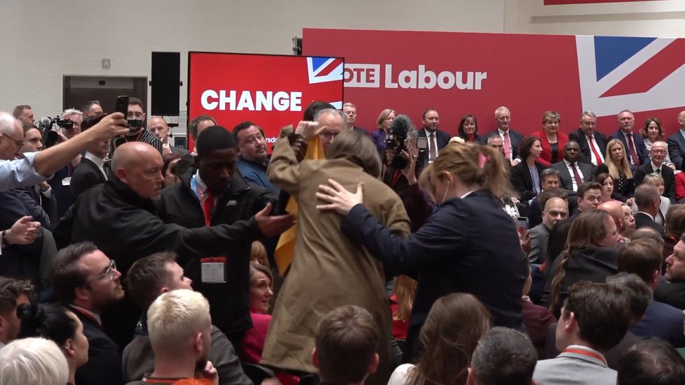 A protester unravels a banner during Keir Starmer's speech