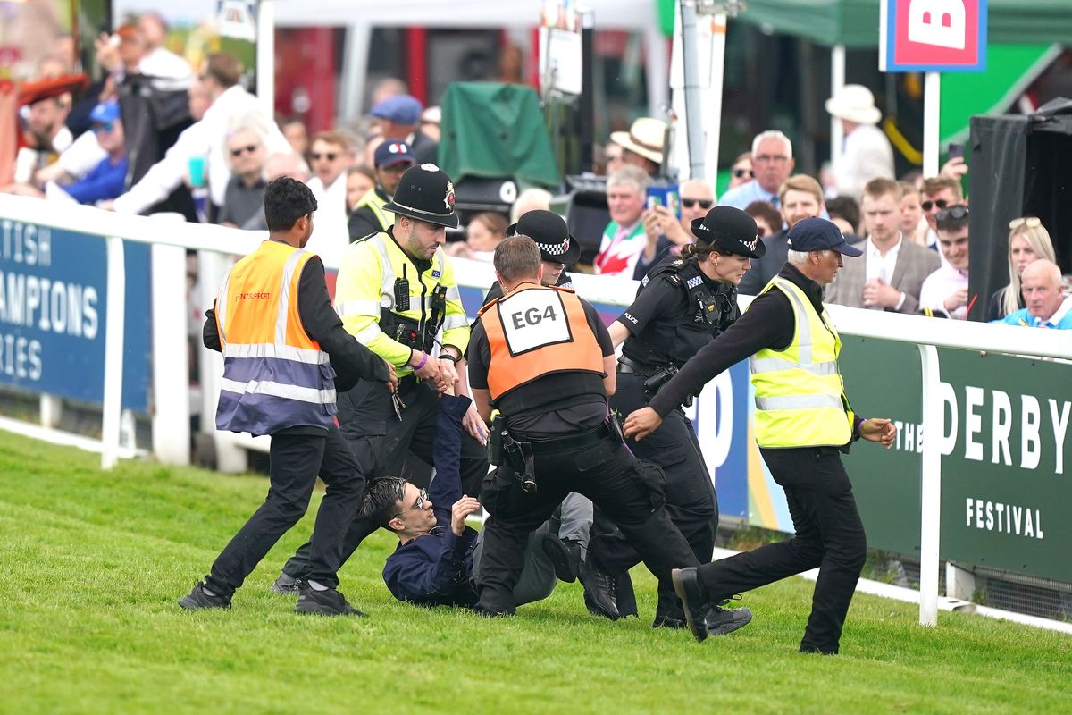 Epsom Derby: Protestor detained by police after running onto racecourse