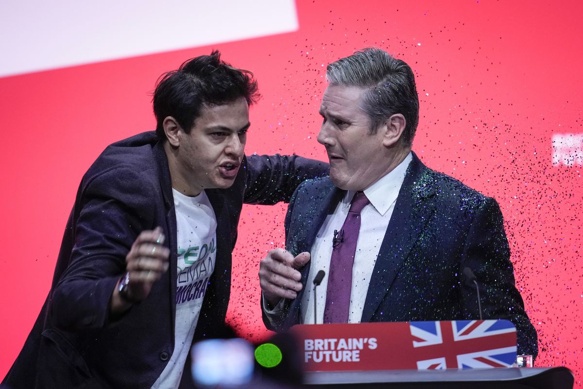 A protestor storms the stage and throws glitter over Labour party leader Sir Keir Starmer