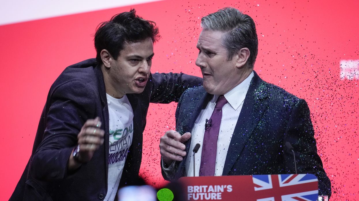 A protestor storms the stage and throws glitter over Labour party leader Sir Keir Starmer