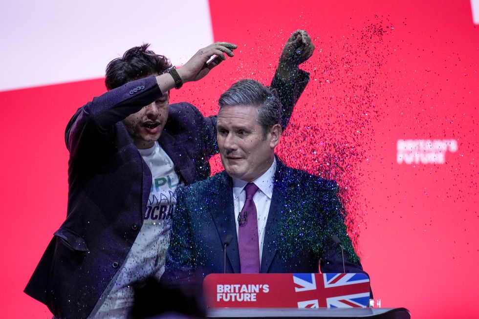 A protestor storms the stage and throws glitter over Labour party leader, Sir Keir Starmer