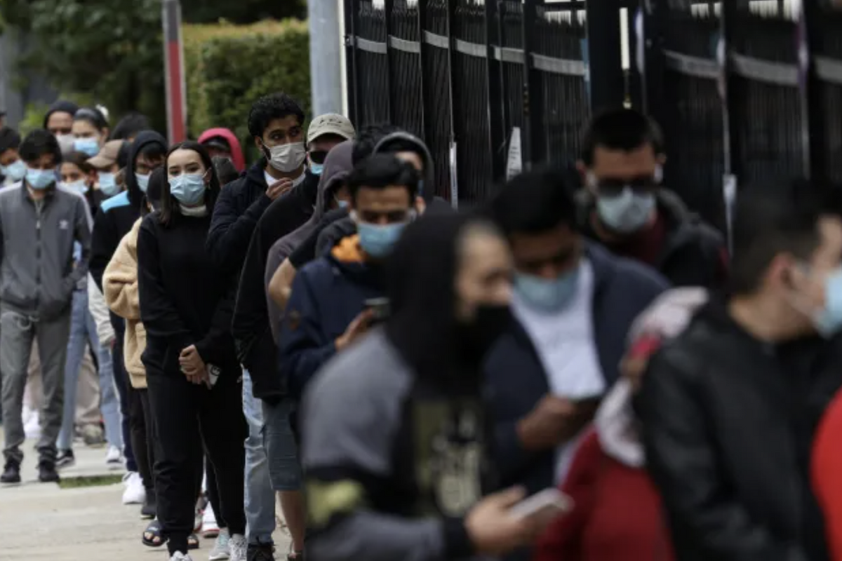 A queue of people wearing masks