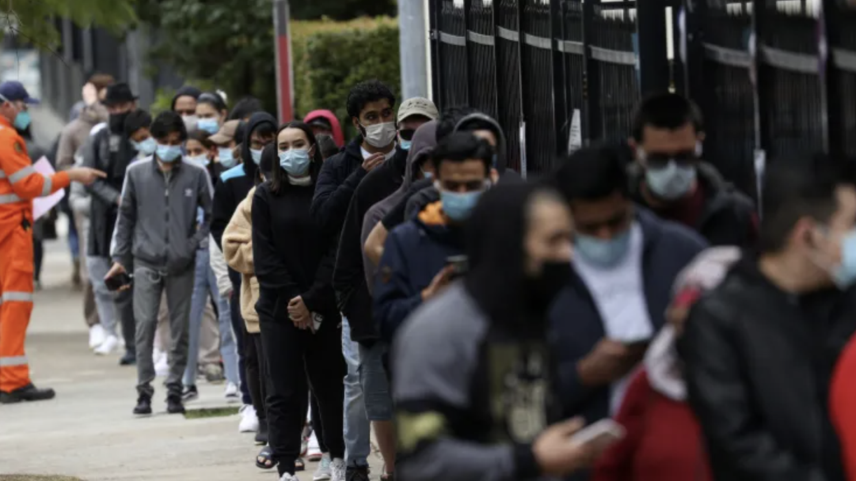 A queue of people wearing masks