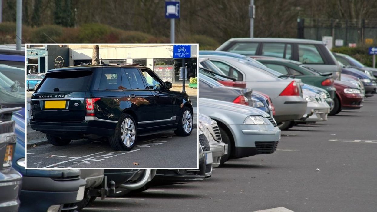 A Range Rover parked over the lines and a car park