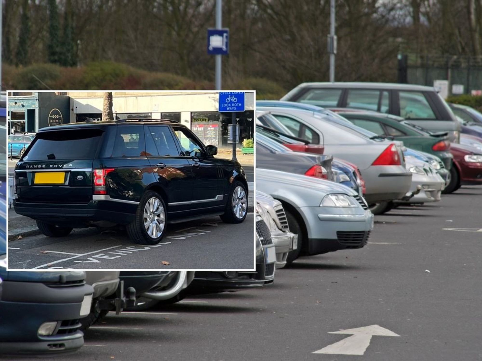 A Range Rover parked over the lines and a car park
