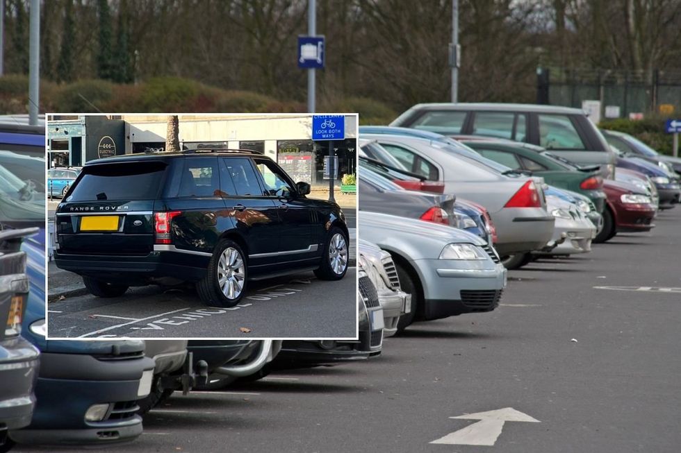A Range Rover parked over the lines and a car park