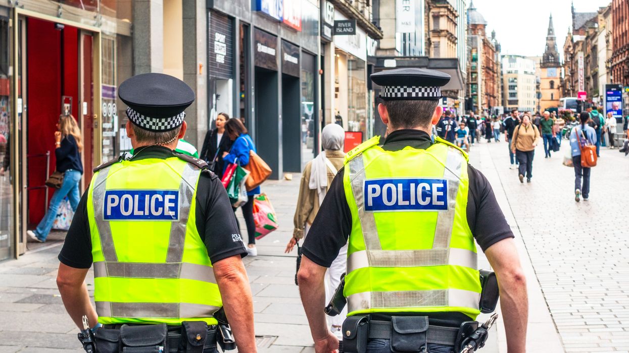 A rear view of two police officers as they walk on Argyll street in Glasgow's city centre