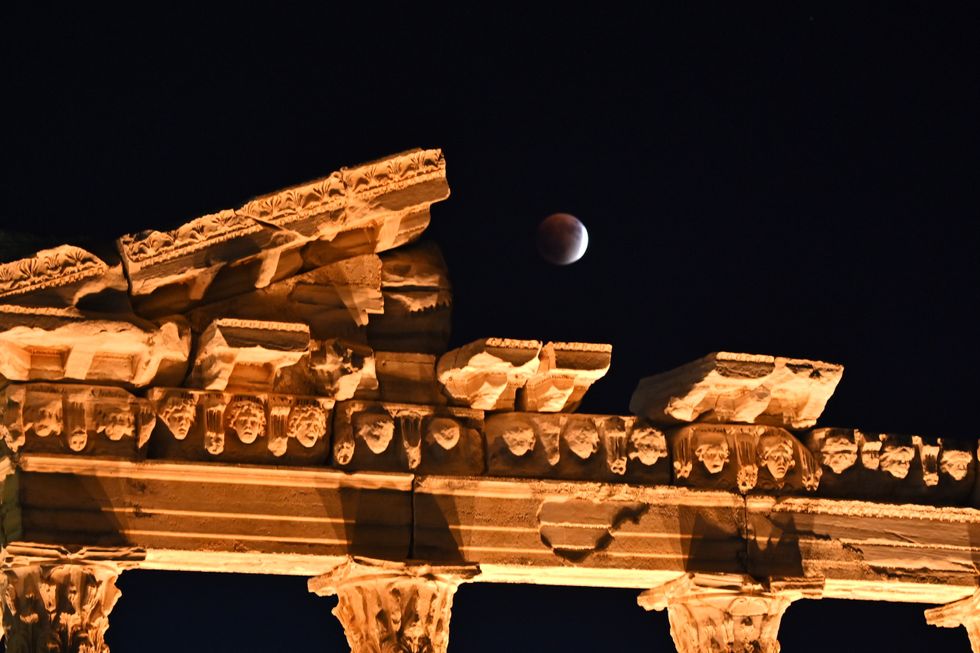 A red full moon, known as the 'Blood Moon' for its hue, appears above the historic Temple of Apollo at the Ancient City of Side in Manavgat district of Antalya, Turkey