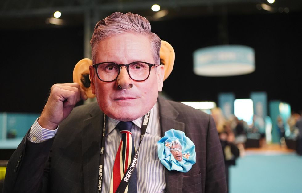 A Reform UK supporter wearing a Sir Keir Starmer mask during the party's annual conference at the National Exhibition Centre in Birmingham
