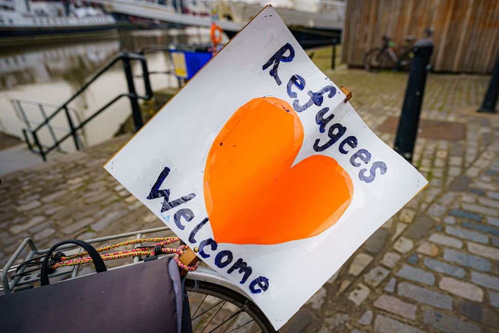 A 'refugees welcome' banner attached to a bicycle by a small flotilla of boats leaving Bristol harbour\u200b