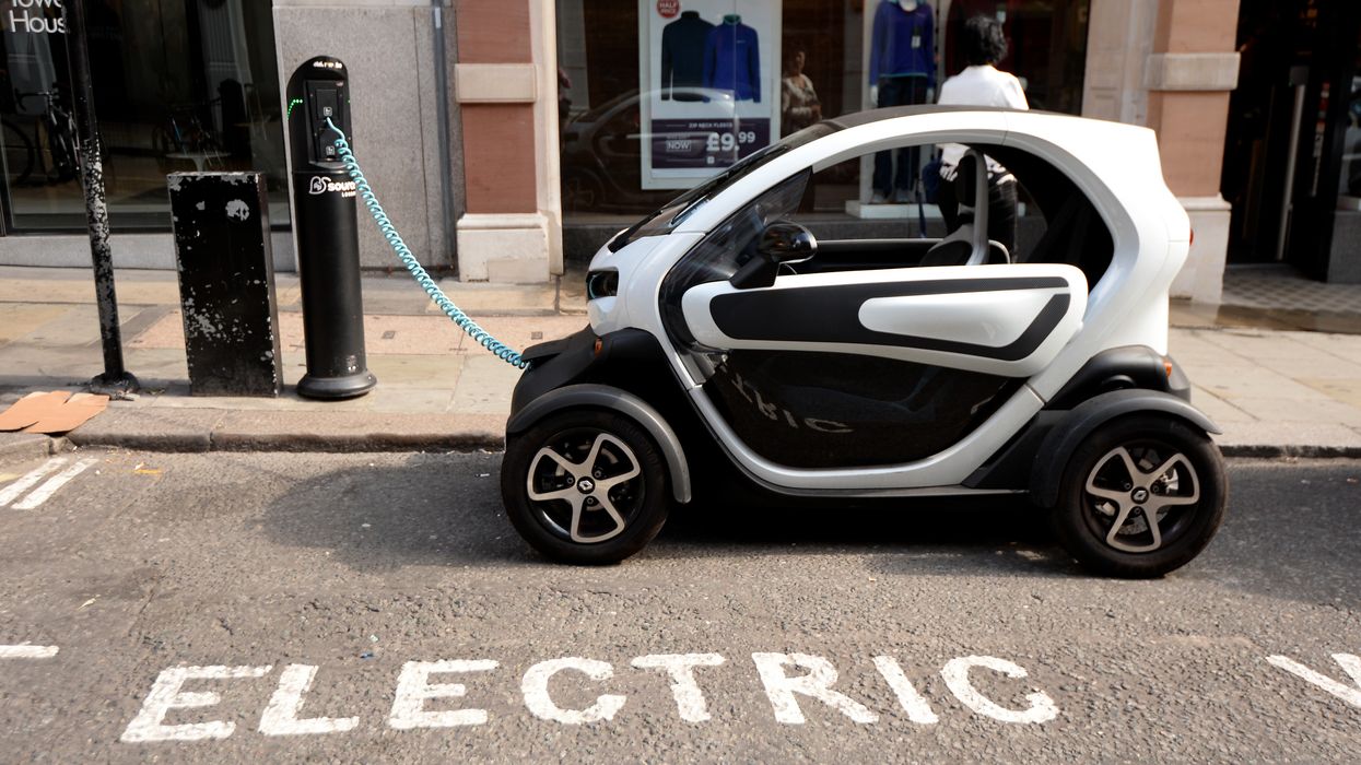 A Renault Twizy, an electric car, is charged form an electric car charging point near to Covent garden market in London.