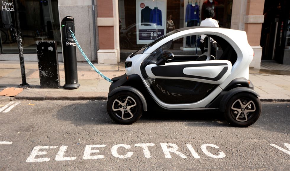 A Renault Twizy, an electric car, is charged form an electric car charging point near to Covent garden market in London.