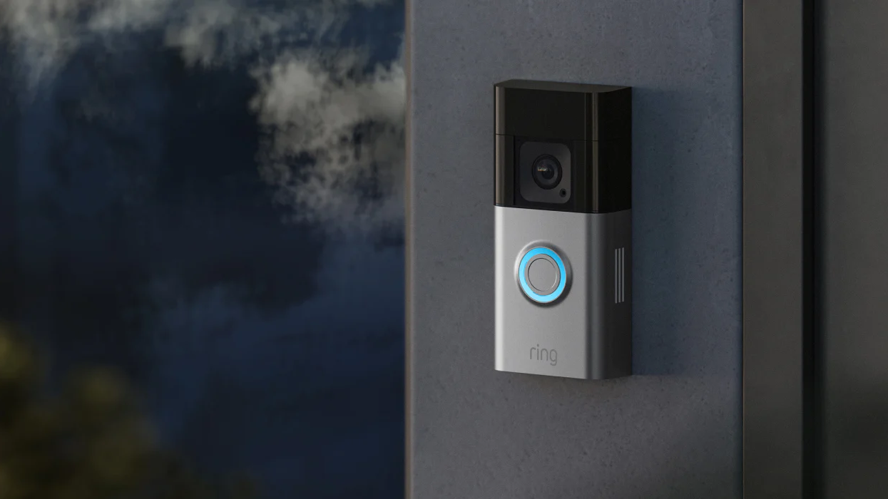 a ring video doorbell fitted to a metal frame around a door with the blue light illuminated
