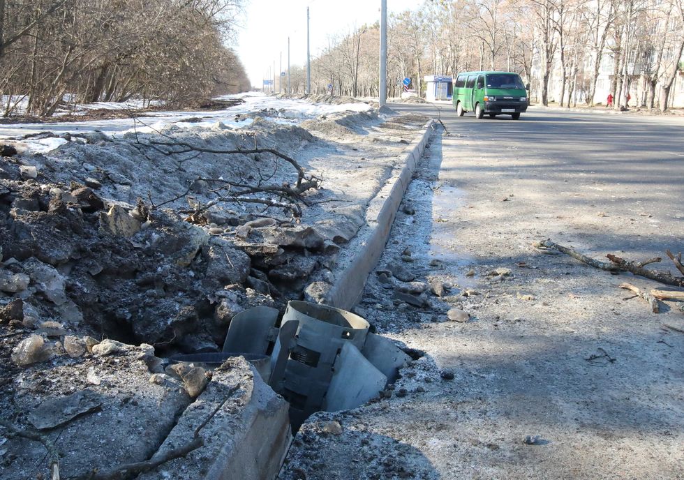 A rocket case lies buried into a road after recent shelling in Kharkiv, Ukraine February 24, 2022. REUTERS/Vyacheslav Madiyevskyy