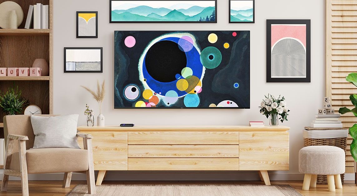 a roku smart tv mounted on the wall with artwork on-screen to blend into the other paintings and art