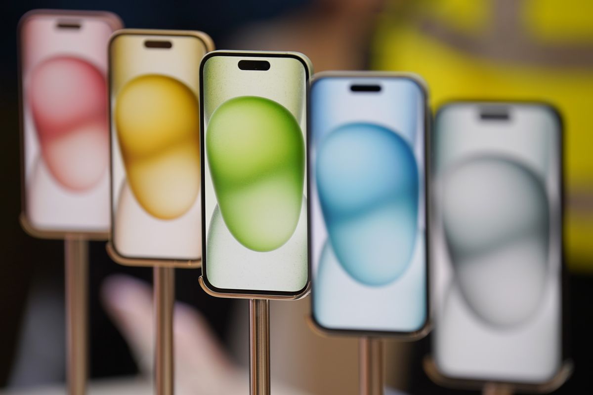 a row of iphone  models in different colours in an apple store 
