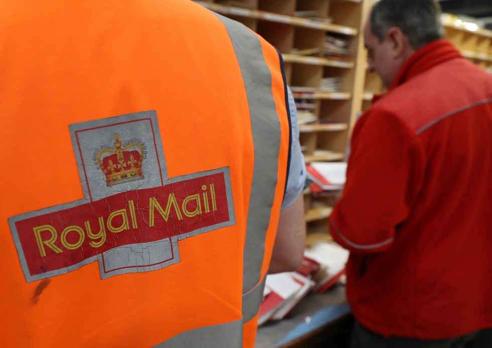 A Royal Mail worker sorts mail at the Royal Mail's Sorting Office in Turner Road, Glasgow.