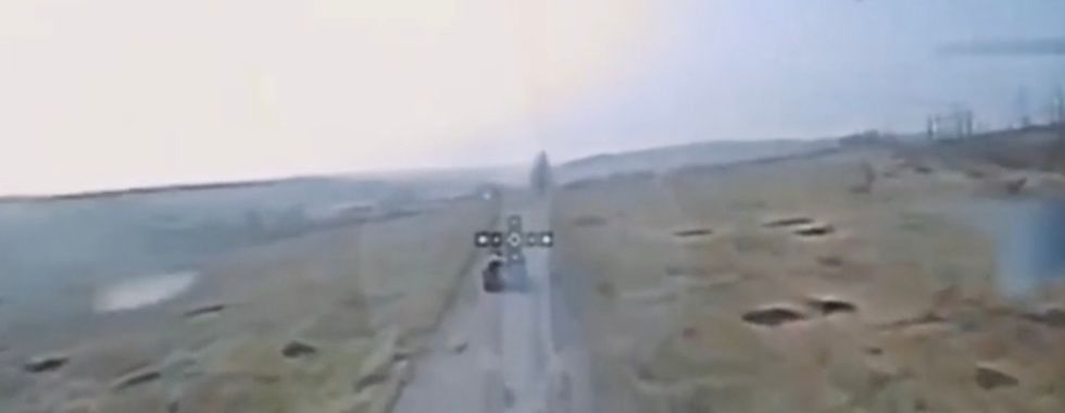 A Russian armoured carrier travels down a road in what looks like the countryside.