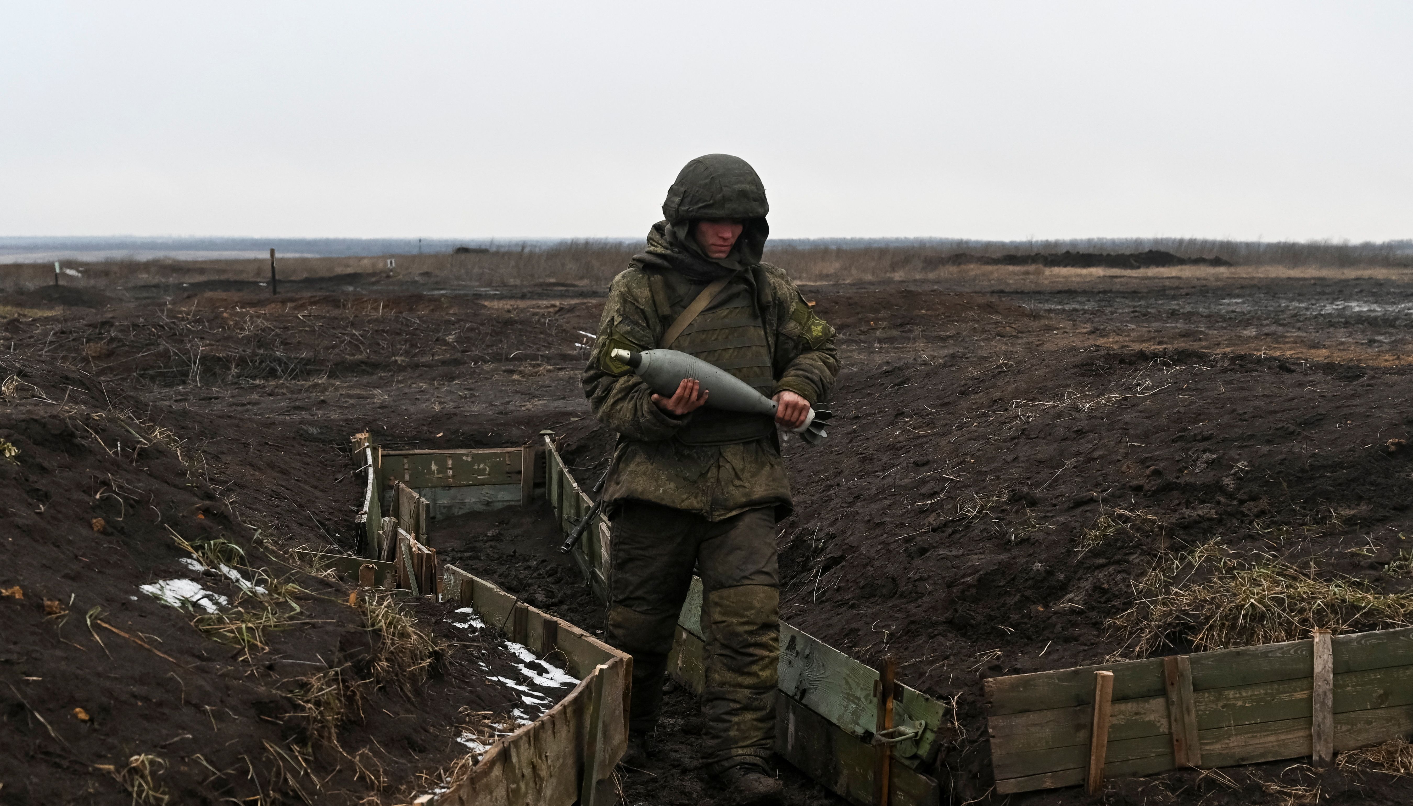 A Russian army service member carries a mortar shell during drills at the Kuzminsky range in the southern Rostov region, Russia.