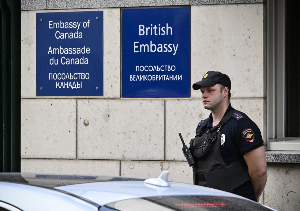 A Russian police officer patrols outside the British embassy building in Moscow