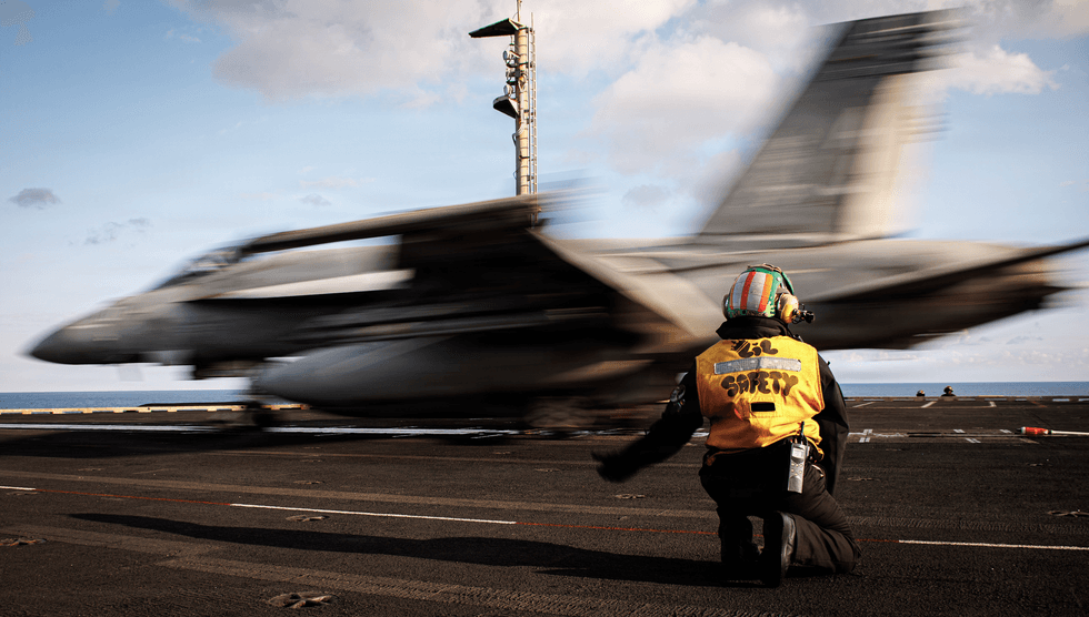A sailor signals the launch of an F/A-18E Super Hornet aircraft, attached to Strike Fighter Squadron 37, aboard the USS Gerald R. Ford (CVN 78), while operating in support of Operation Epic Fury on March 2, 2026 in the Eastern Mediterranean Sea.