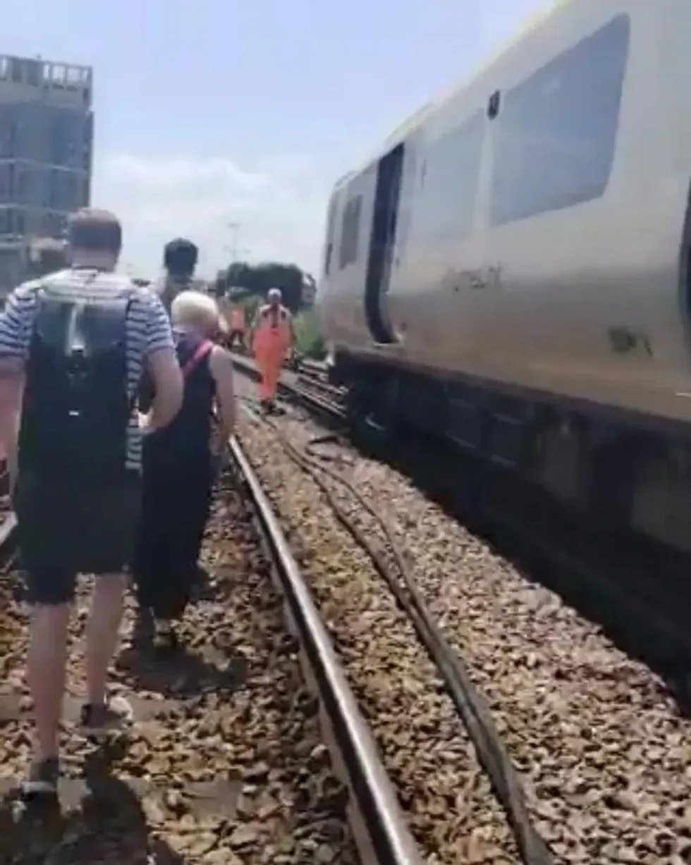 A screenshot of passengers walking along the tracks
