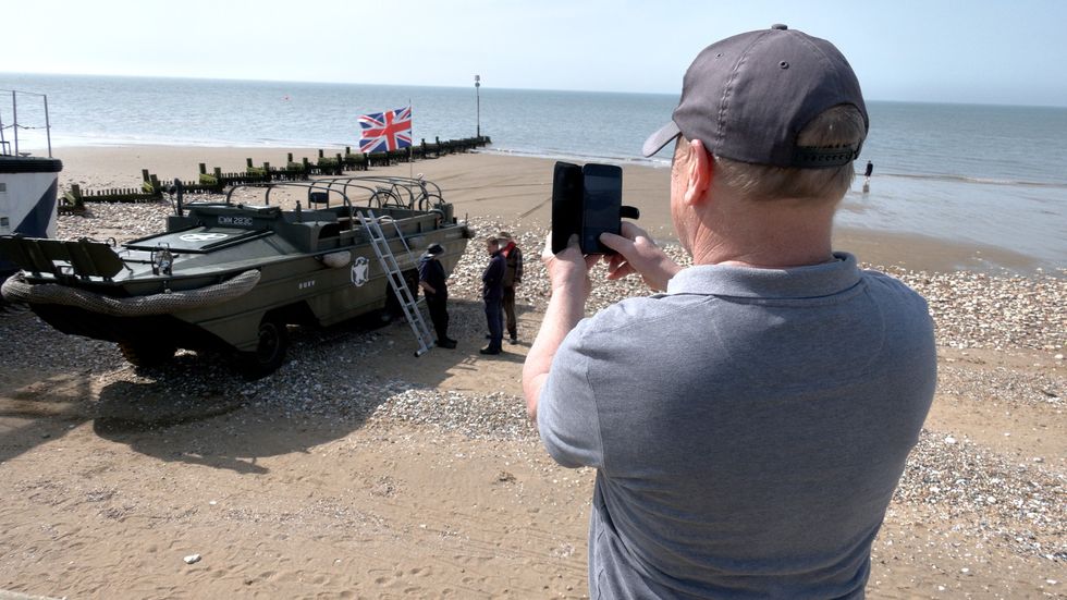 A seaside tourist snaps a photo of the iconic Second World War vehicle