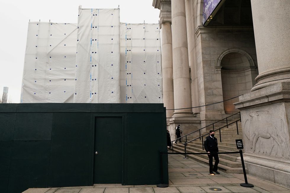 A security guard walks around the exterior of the American Museum of Natural History where the equestrian statue of Theodore Roosevelt was removed last night, in the Manhattan borough of New York City, New York