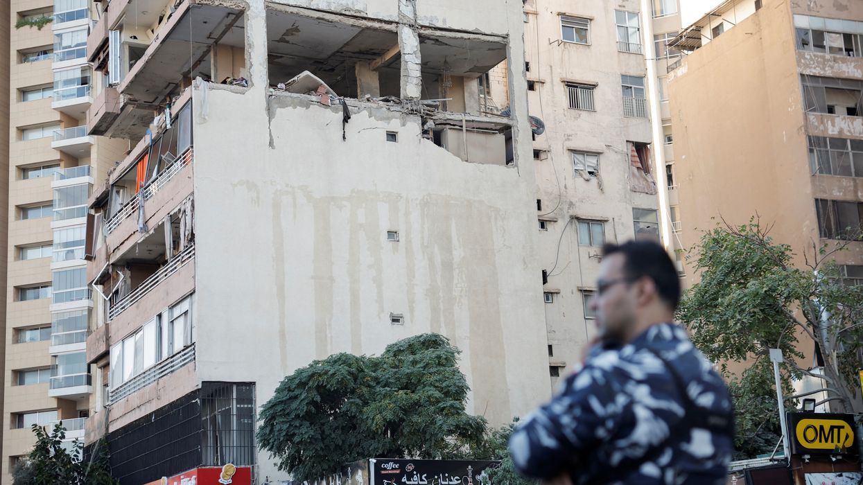 A security personnel stands next to the buildings damaged in an Israeli strike, amid ongoing cross-border hostilities between Hezbollah and Israeli forces, in Kola, central Beirut