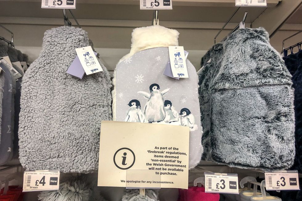 A sign in front of hot-water bottles advises customers some items may not be purchased, in line with Welsh Government firebreak regulations, in a supermarket near Cardiff as Wales entered a two-week %22firebreak%22 lockdown from Friday in an attempt to protect the country's NHS from being overwhelmed by the resurgence of coronavirus.