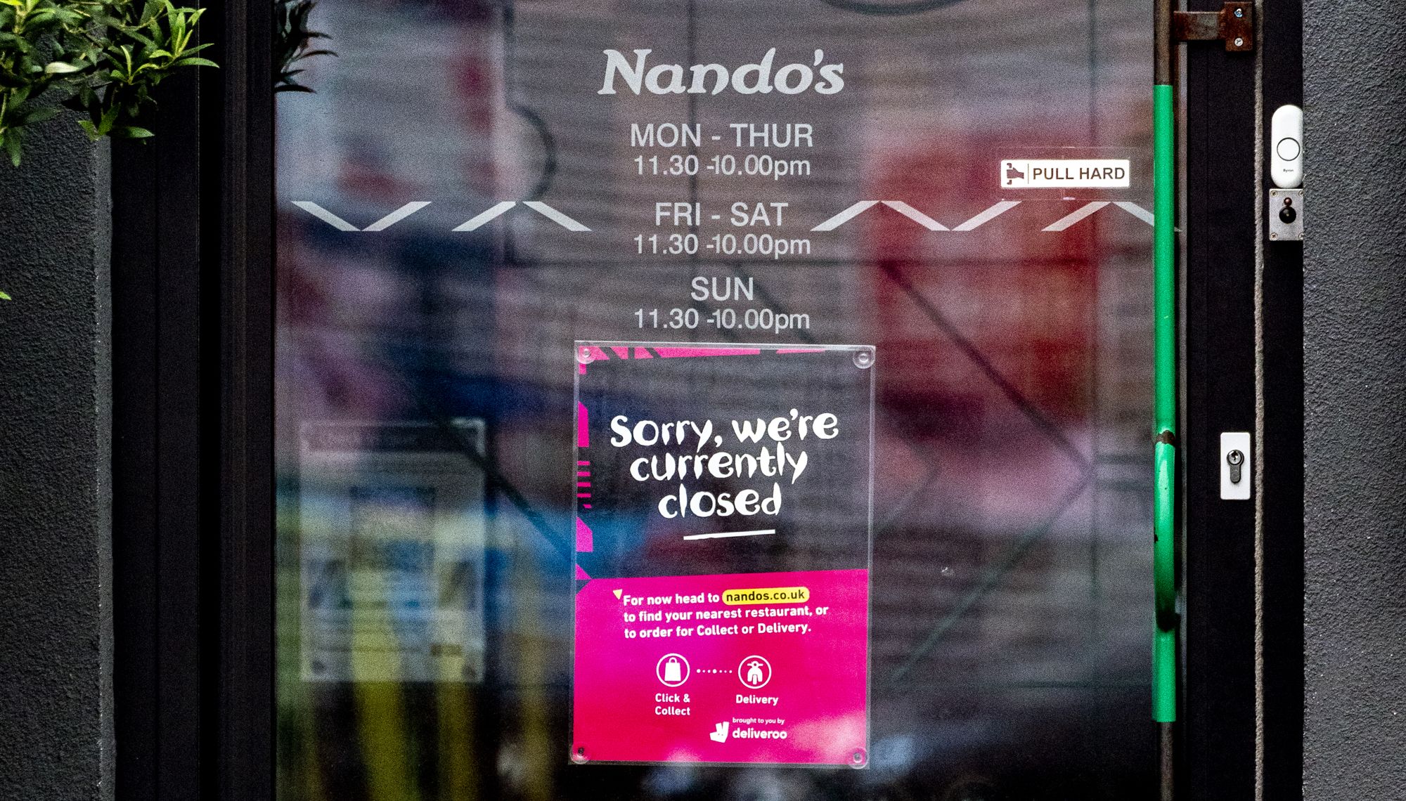 A sign on the doors of a branch of Nando's in White City, Manchester, telling customers that the store is closed.
