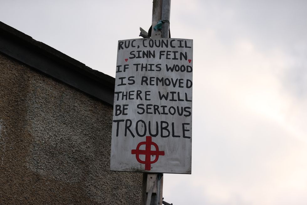 A sign posted on a lamppost near to the site of a large bonfire being built to mark the Catholic Feast of the Assumption in the Bogside area of Londonderry, Northern Ireland. Picture date: Sunday August 15, 2021.