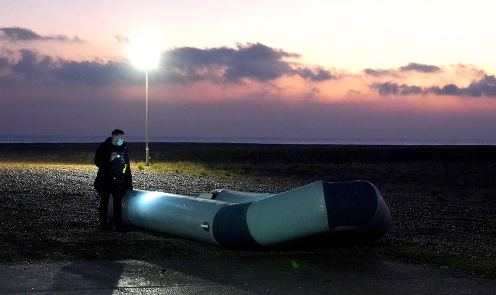 A small boat used by a group of people thought to be migrants is inspected after being brought in to Dungeness, Kent, by the RNLI following a small boat incident in the Channel. Picture date: Saturday January 15, 2022.