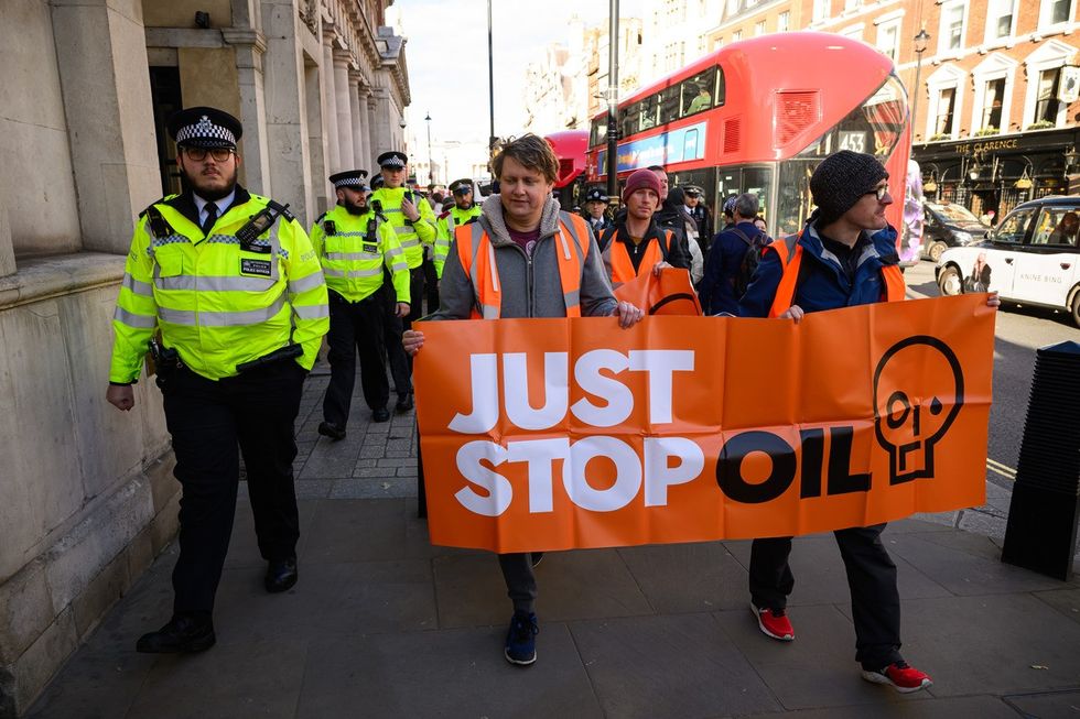 A small group of Just Stop Oil protestors are escorted by the police during a demonstration on Whitehall on November 24, 2023
