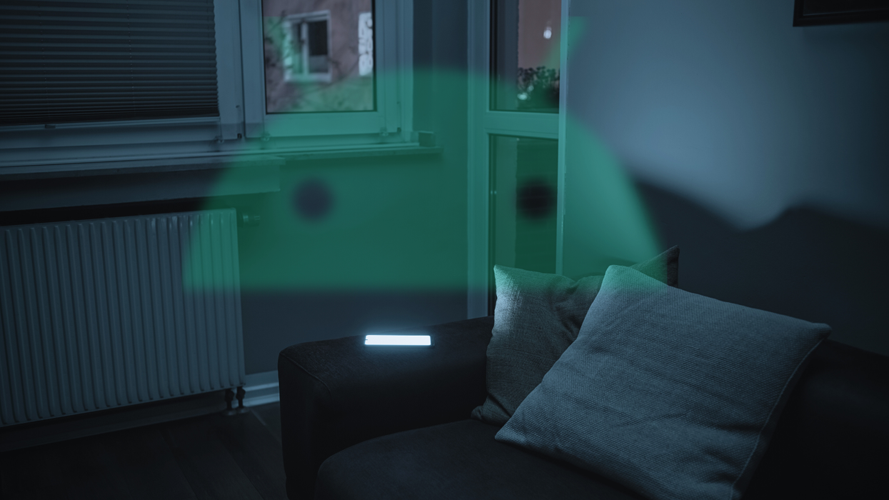 a smartphone screen illuminates a darkened room with an android logo superimposed