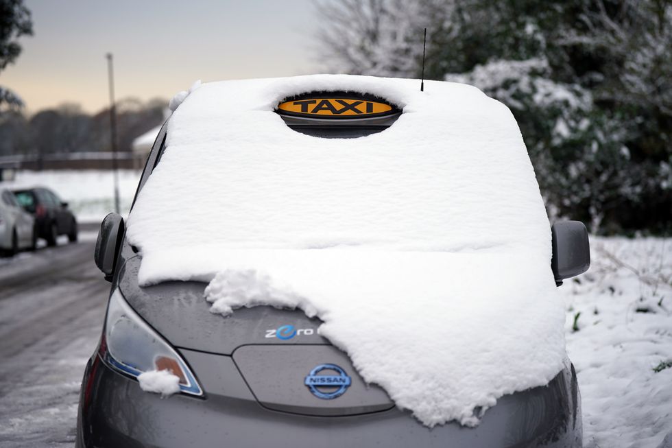A snow covered taxi in London. Snow and ice have swept across parts of the UK, with cold wintry conditions set to continue for days. Picture date: Tuesday December 13, 2022.