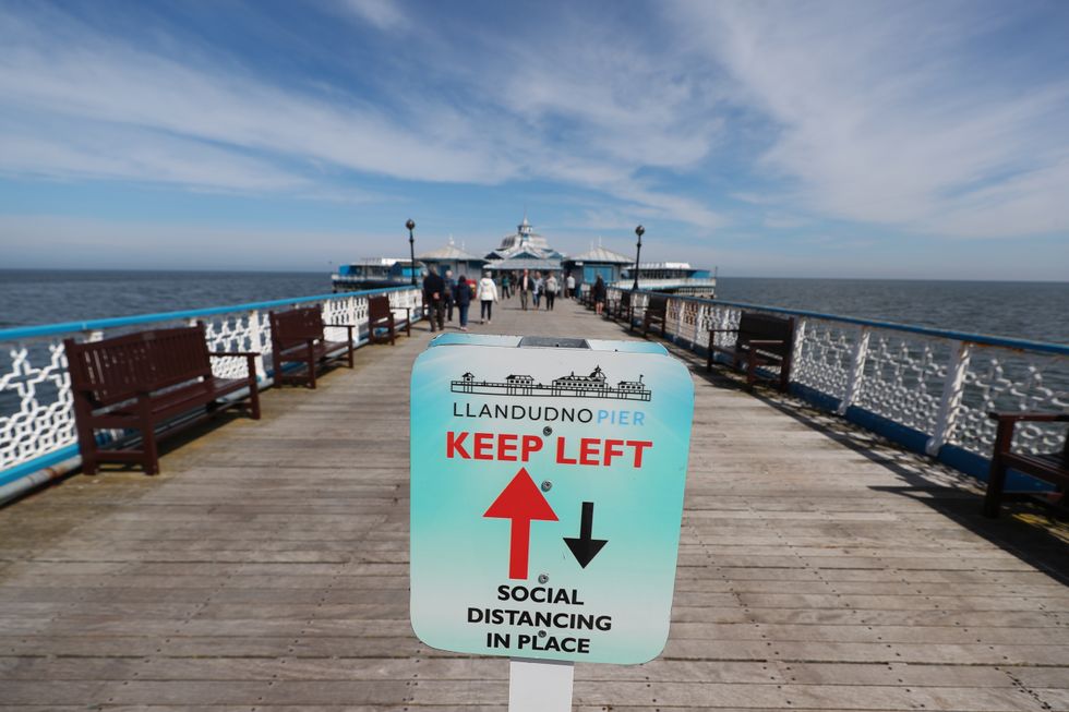 A social distancing sign on the pier in Llandudno, Wales