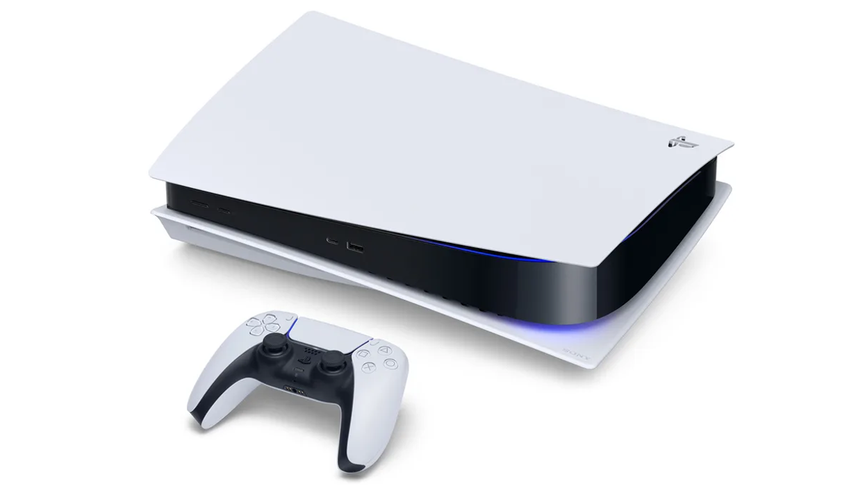 a sony ps5 lying on its side with the controller infront of it