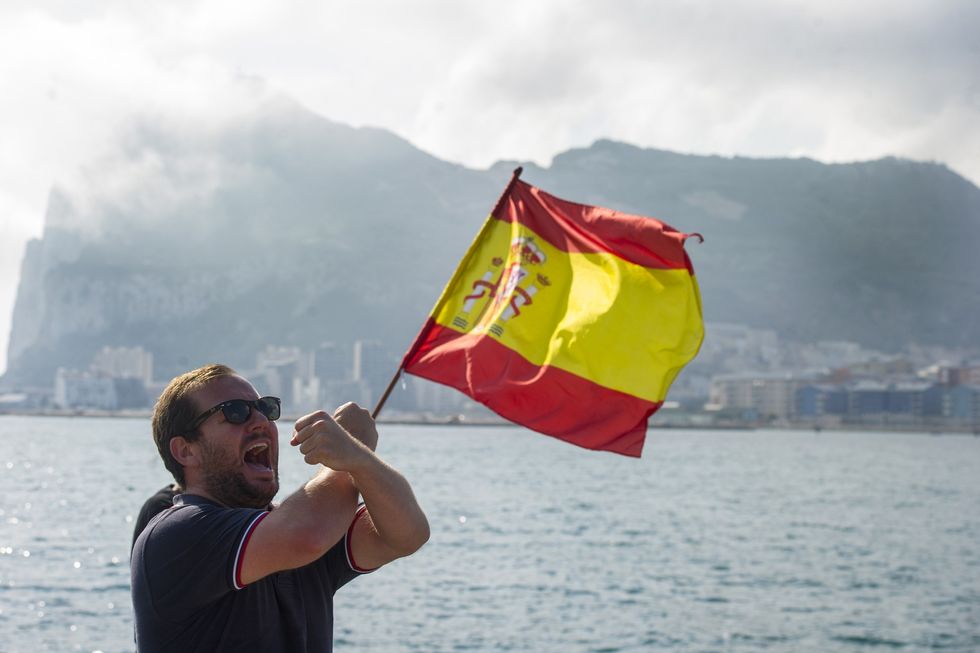 A Spanish fisherman holds a Spanish flag during a protest in the bay of Algeciras, near the Rock of Gibraltar